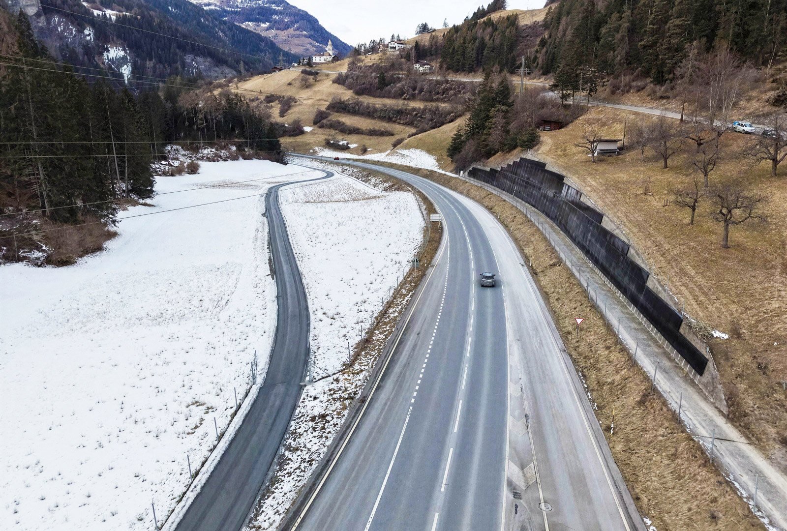 Luftaufnahme der Julierstrasse mit der Sichtbetonmauer, an der die PV-Anlage montiert wurde. Die Mauer erstreckt sich entlang der Hauptverkehrsachse im Albulatal. 